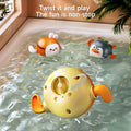 Three wind-up swimming bath toys shaped like a bunny, penguin, and duck float in a bathtub. The yellow duck toy is shown upside down, revealing the wind-up mechanism on its underside with an arrow indicating the twisting direction.