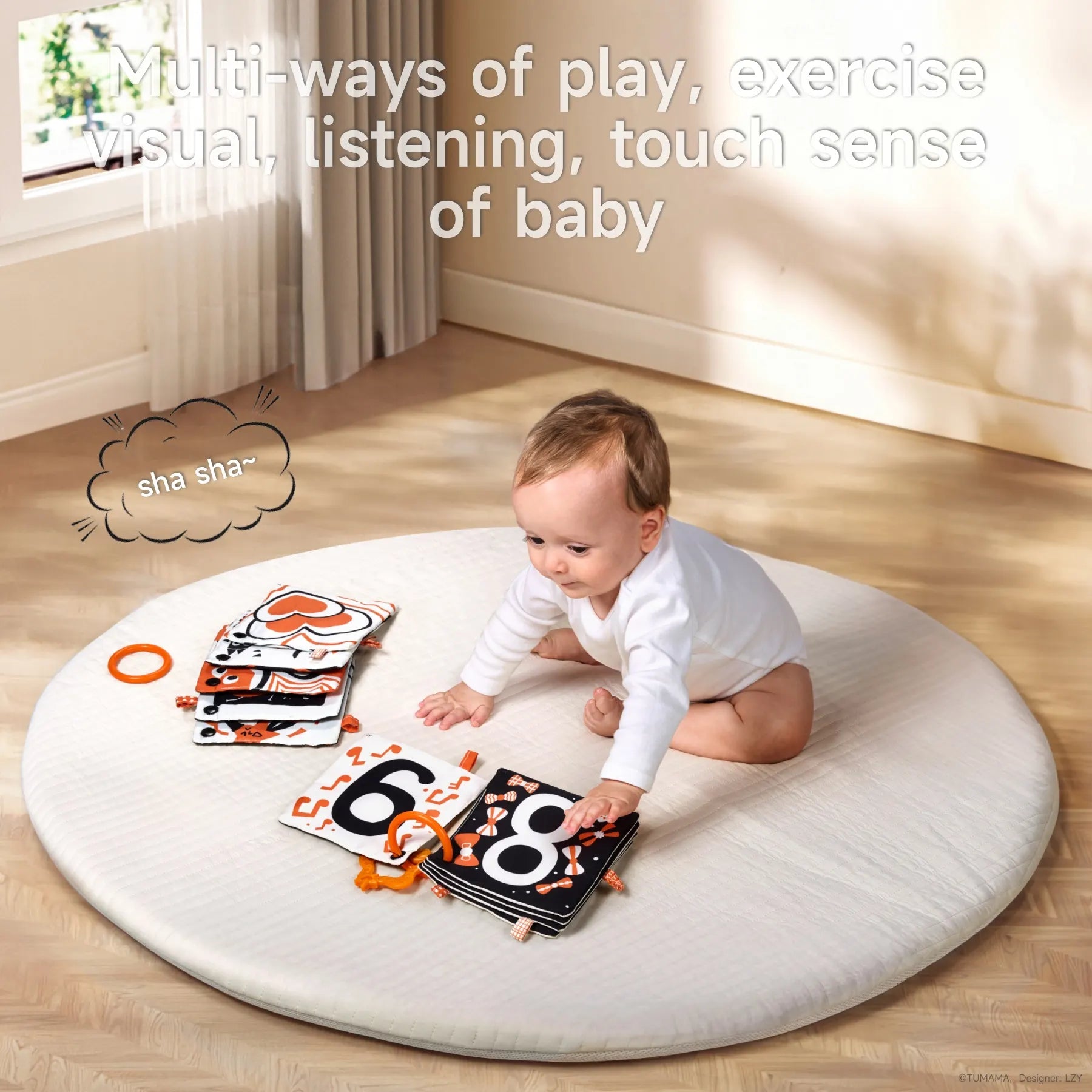 A baby sits on a round white mat in a sunlit room, engaging with black, white, and orange high-contrast soft cloth books featuring large numbers and patterns. The text above reads “Multi-ways of play, exercise visual, listening, touch sense of baby,” and a playful “sha sha~” sound bubble appears, indicating a crinkly sound feature for sensory stimulation.