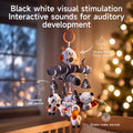 Black-and-white newborn crib mobile hanging by an orange ring in a softly lit nursery, featuring a plush birch-patterned branch with dangling toys (owl, panda, star, pelican, bat); graphic arrows label interactive sound features: shaking the owl produces a ‘Ding’ bell sound, squeezing the star triggers BB rattle noises, and shaking the bat activates additional chime sounds.