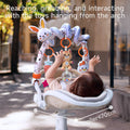 Baby lying in a stroller, actively reaching and grabbing plush animal toys hanging from a soft arch toy bar during an outdoor walk; suitable for strollers under 70cm wide.