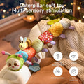 Colorful plush caterpillar toy with attached smiling bee and pineapple teether draped over a sofa arm in a softly lit room, highlighting its multi-sensory benefits for hearing, visual development, entertainment, and safe materials