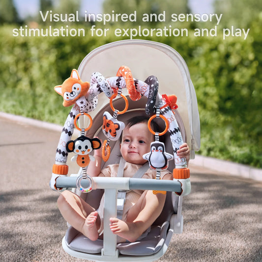 Baby sitting in a stroller, interacting with a colorful hanging toy arch featuring plush animals like a penguin, monkey, and tiger, designed for visual and sensory stimulation during outdoor play.