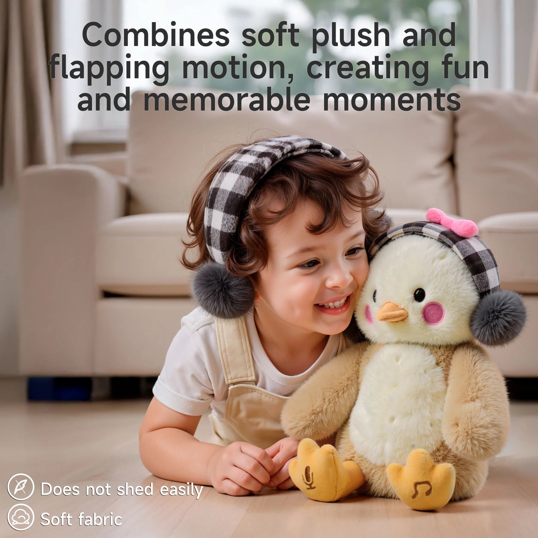Happy child lying on the floor and cuddling a soft, interactive chick plush toy with flapping motion, wearing matching checkered earmuffs, highlighting its durable, shed-resistant, and soft fabric features.