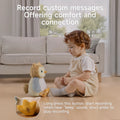 Young child sitting on the floor facing an interactive owl plush toy in a cozy living room. Text above reads: 