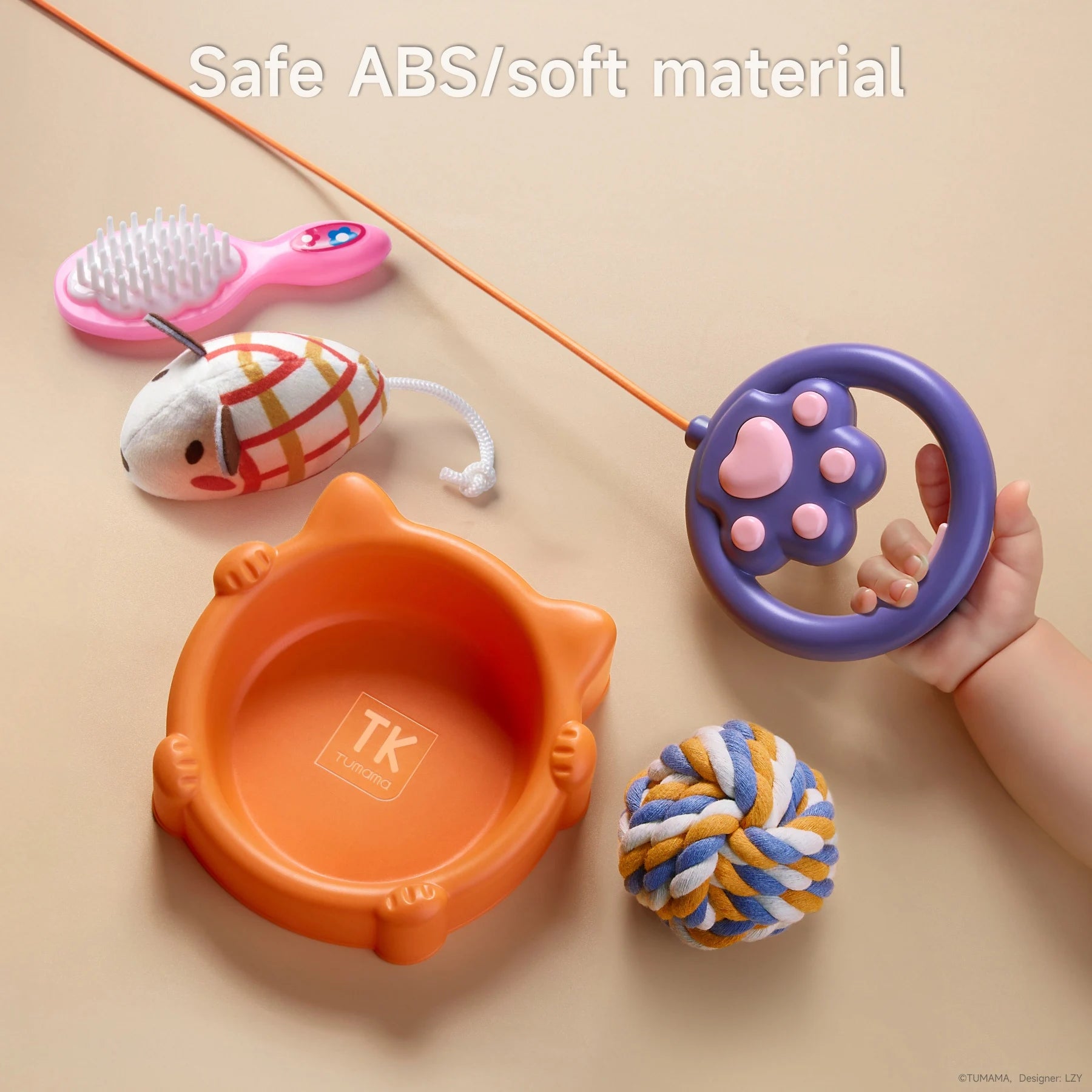 Close-up of toy cat accessories made of safe ABS and soft materials, including a pink brush, fabric mouse toy, orange cat-shaped bowl, plush rope ball, and purple paw-shaped leash handle held by a toddler.