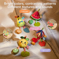 A versatile set of fruit-themed hanging toys shown in three settings: a baby playing with them on a crib, attached to a car seat, and on a wooden play gym. The toys include plush fruit characters with dangling teethers and sensory features, designed to entertain and aid in development. Text highlights their use for cribs, car seats, and play gyms.