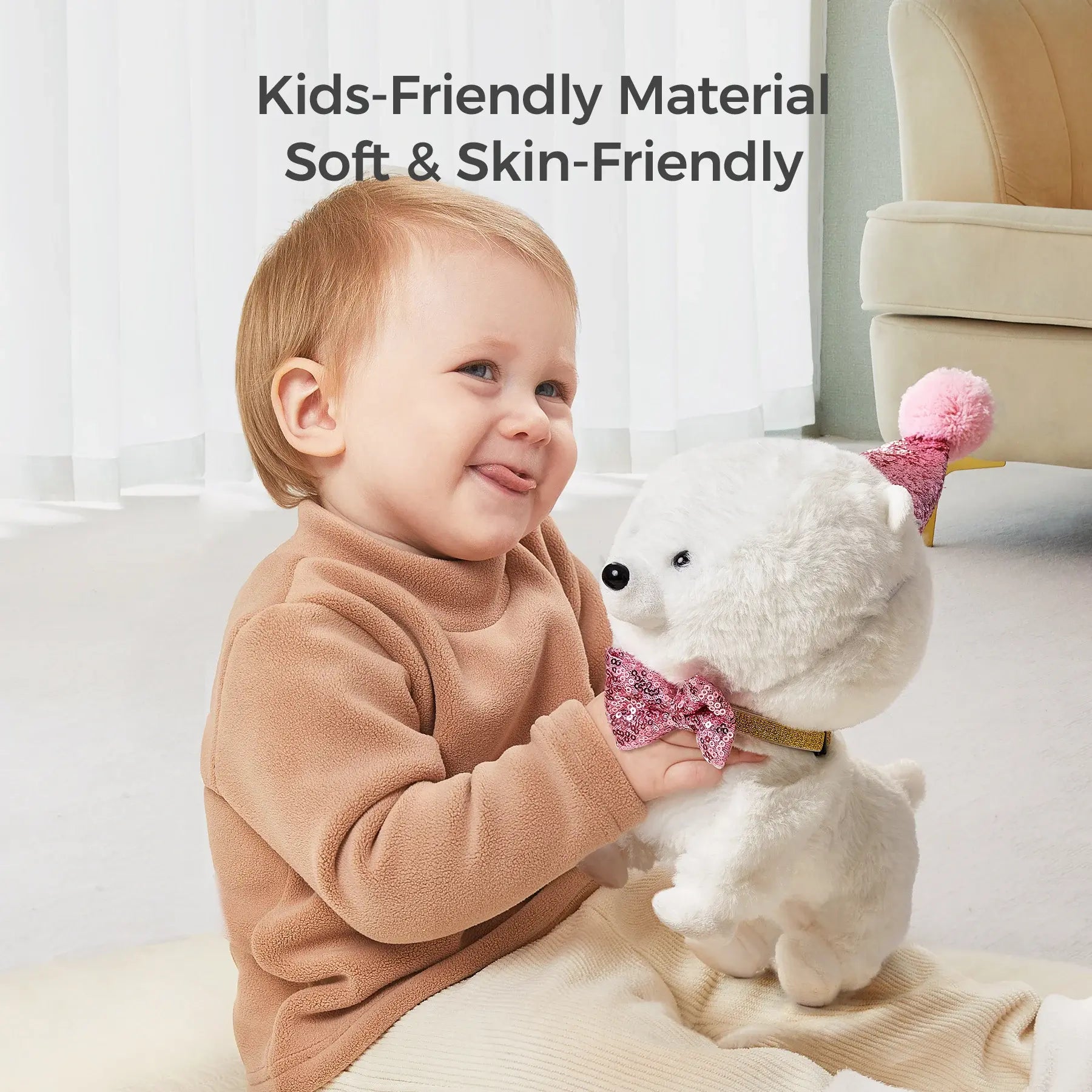 Smiling toddler sitting on the floor indoors, holding a fluffy white interactive toy dog with a pink sequin bowtie and party hat. The scene emphasizes the toy's soft, skin-friendly material suitable for kids.