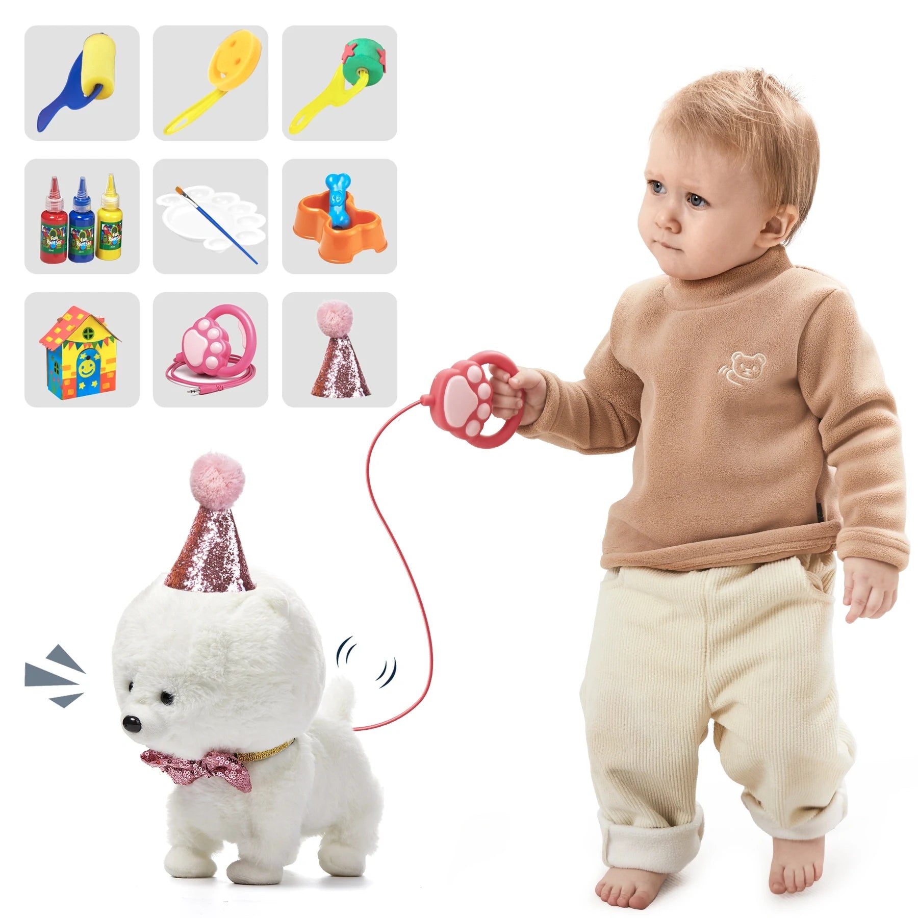 Toddler holding a pink paw-shaped remote control, leading an interactive white plush toy dog with a party hat and bow tie; various painting tools and toy accessories displayed on the left, including paint bottles, brushes, food bowl, doghouse, and hat.