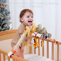 Smiling toddler standing in crib holding onto a plush koala-themed spiral arch toy with hanging giraffe, parrot, teether, and rattle. Caption reads: “Stable stand stretchy PP material, shaking does not fall down.”