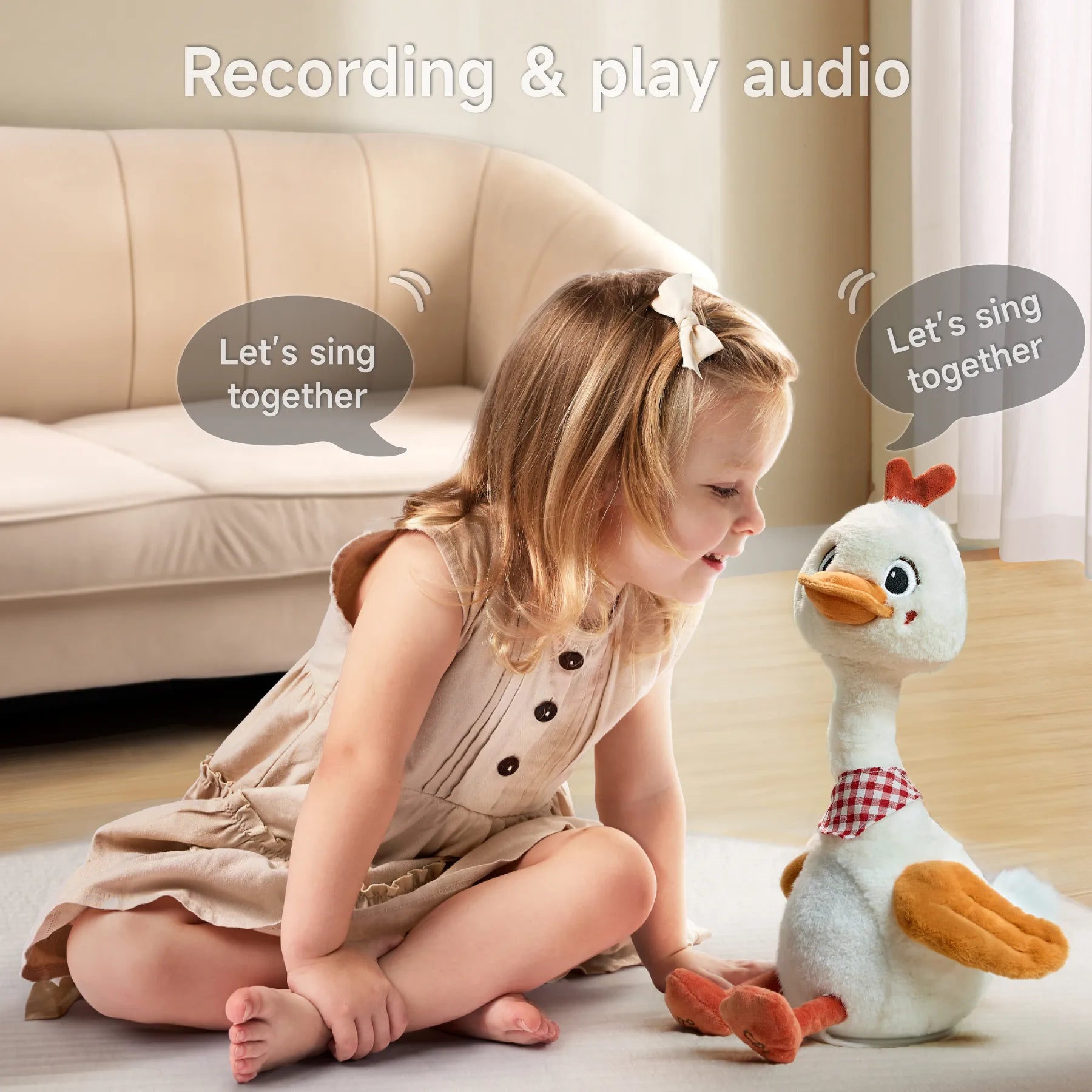 A smiling girl interacts with a recording and play audio feature of the talking and dancing duck toy. The duck says 'Let's sing together,' while the girl enjoys the interaction. The toy is sitting next to her as they play.