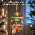 A close-up of a Woodland Animal Crib Mobile hanging indoors in a softly lit room. The mobile features a green tree branch design with a yellow bee and red flower at the top, and plush toys including stars, a ladybug, an owl, a strawberry, a sloth, and a raccoon. The background is cozy with blurred plants and window, and text over the image reads, 