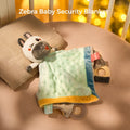 Zebra Baby Security Blanket displayed on a crib mattress with a pillow, featuring a plush zebra head, soft textured blanket, and teething rings
