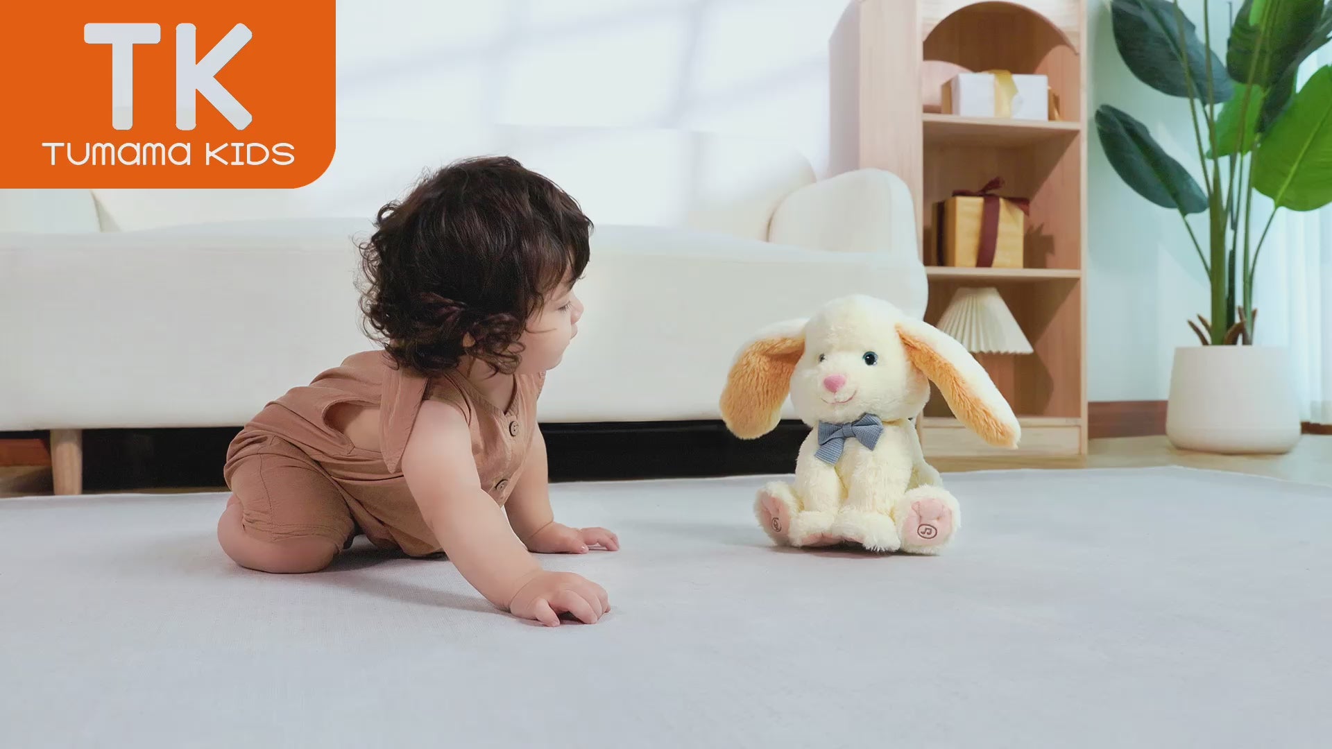 Video of a baby happily playing with the Stuffed Electric Rabbit Bunny Toy on the sofa