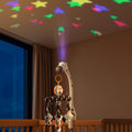 White and white Zebra-shaped bassinet mobile with hanging black, white, and orange plush animal toys, featuring music and star projection light.